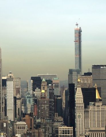 2-people-climb-to-the-top-of-empire-state-building-spire,-unfurl-banner