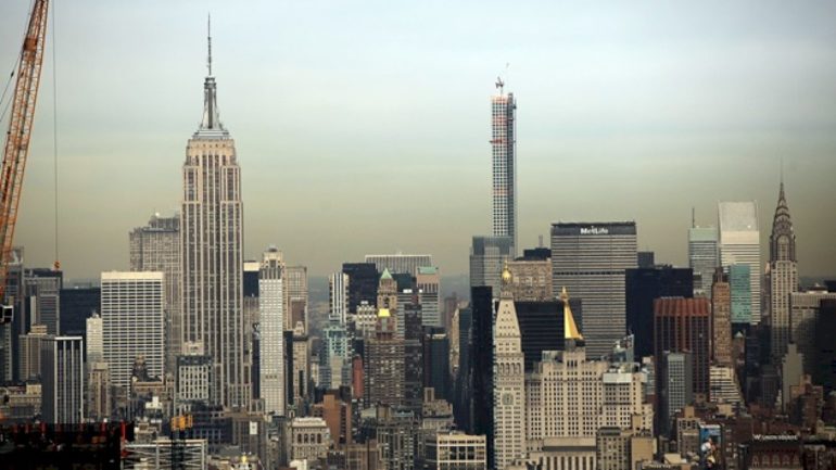 2-people-climb-to-the-top-of-empire-state-building-spire,-unfurl-banner